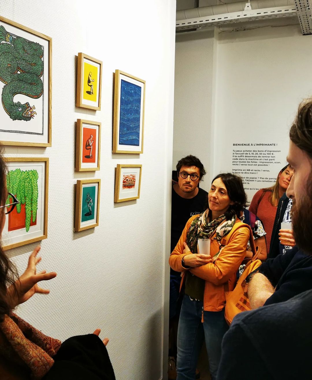 Aperçu de l'exposition Baam sur les murs de La Colloc avec des oeuvres des Cas Brassés et le public regardant les oeuvres